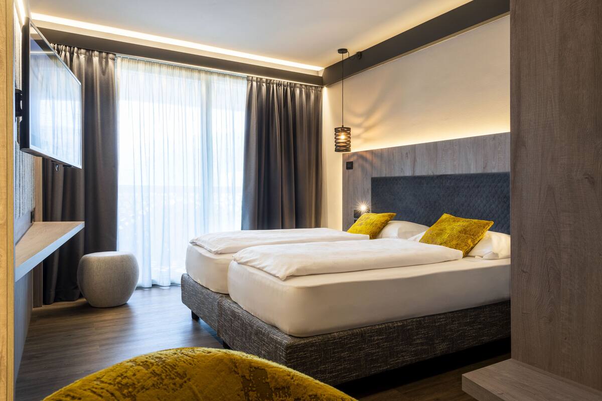 Una habitación de hotel moderna con una cama grande, un televisor de pantalla plana y una zona de estar acogedora.
