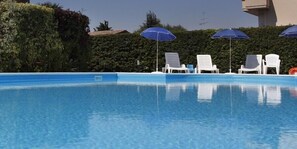 Een seizoensgebonden buitenzwembad en parasols bij het zwembad