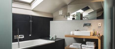 A modern bathroom with a freestanding bathtub, a vanity with a sink, and a mirror.