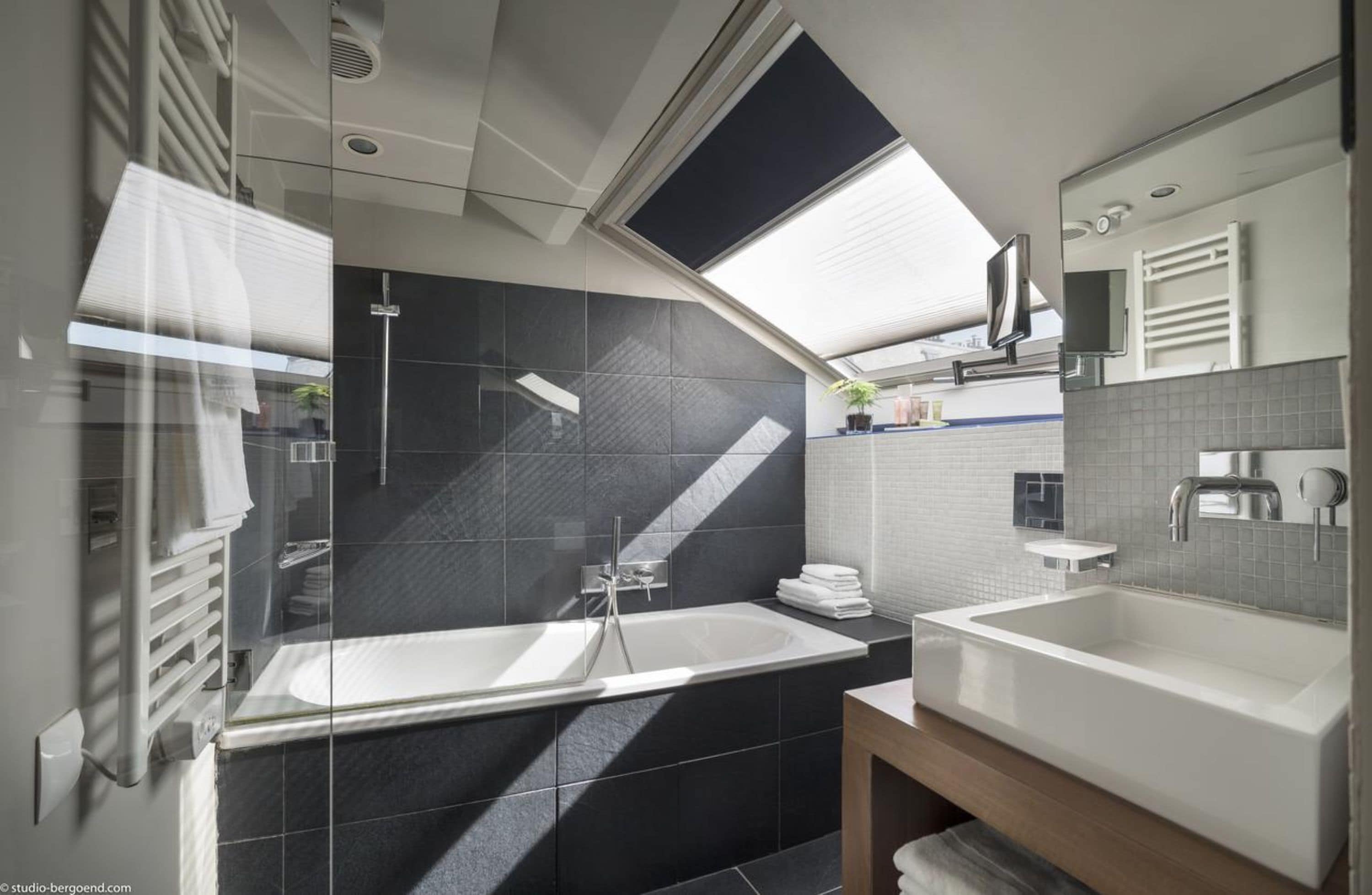 Un bagno moderno con una vasca da bagno ampia, un lavabo separato e una doccia.