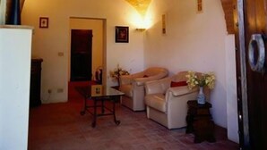 Una sala de estar con techo abovedado, un sofá, una mesa y una puerta.