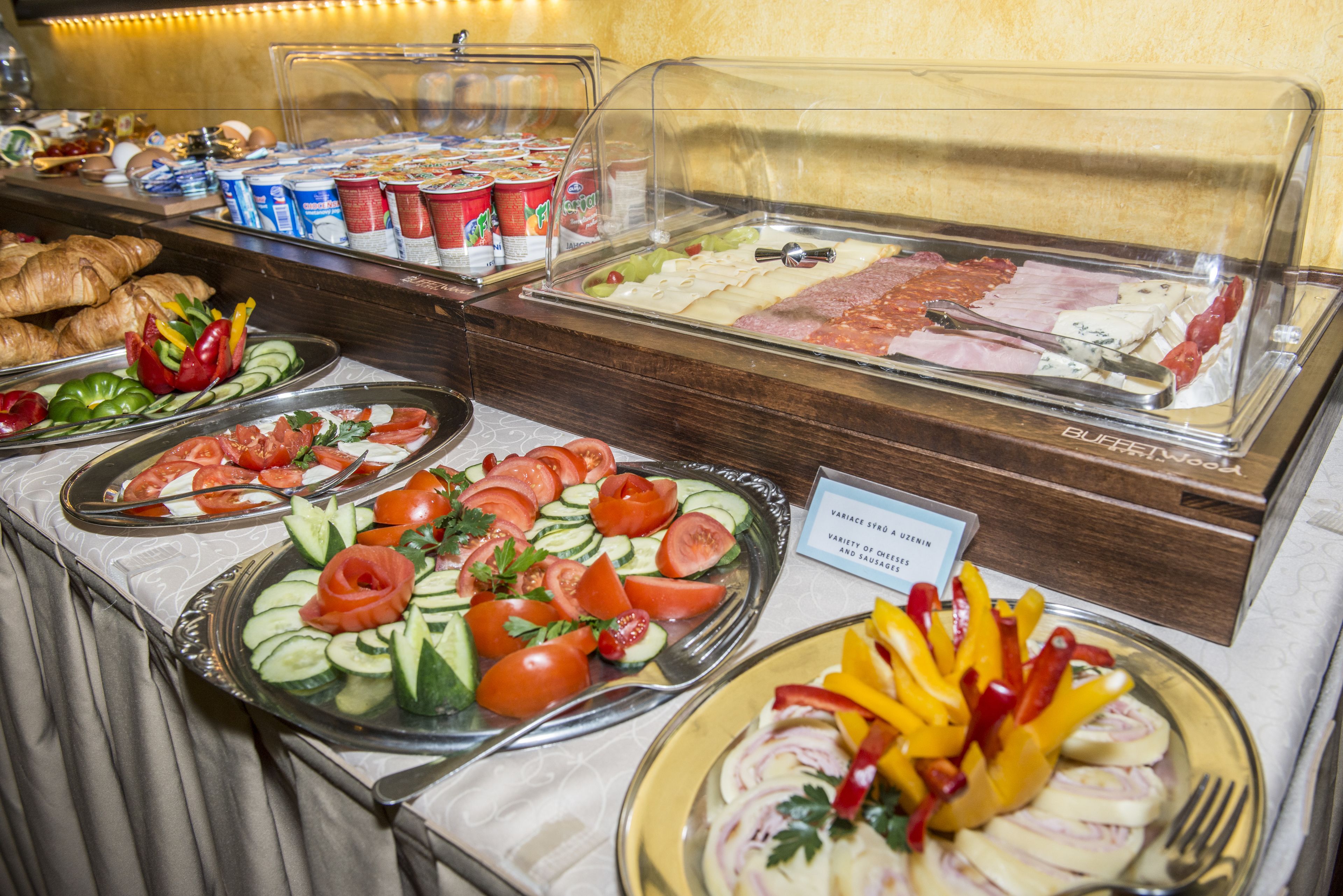A buffet with various food items including salads, meats, and pastries.