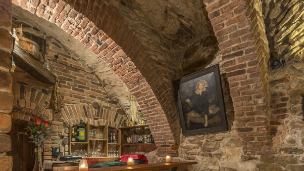 Un coin bar au style rustique, avec des murs en briques, un comptoir en bois et des tabourets de bar.