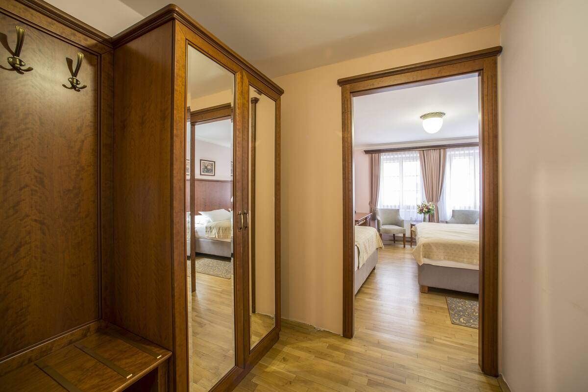 Ein Hotelzimmer mit Holzschrank, Bett, Schreibtisch und Stuhl.