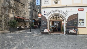 Un café avec une terrasse, une enseigne indiquant une offre quotidienne et une entrée bien visible.