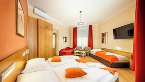 Habitación de hotel con dos camas, un sofá, un televisor y una cortina roja.