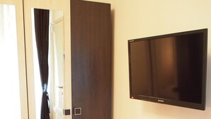 A room with a sliding door, a flat-screen TV mounted on the wall, and wooden flooring. - Budapest Royal Suites II (Budapest)