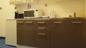 A compact kitchen with a microwave, coffee maker, and kettle. - Budapest Royal Suites II (Budapest)