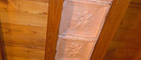A wooden ceiling with decorative paneling and exposed beams.