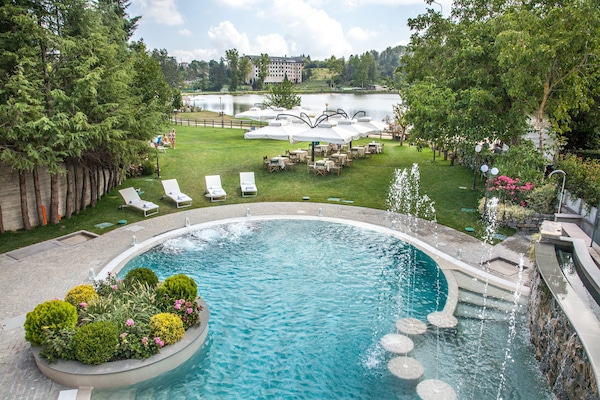 Una piscina cubierta, una piscina al aire libre, tumbonas