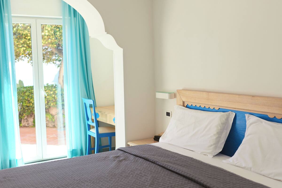 Una camera da letto con un letto, una scrivania e una sedia.