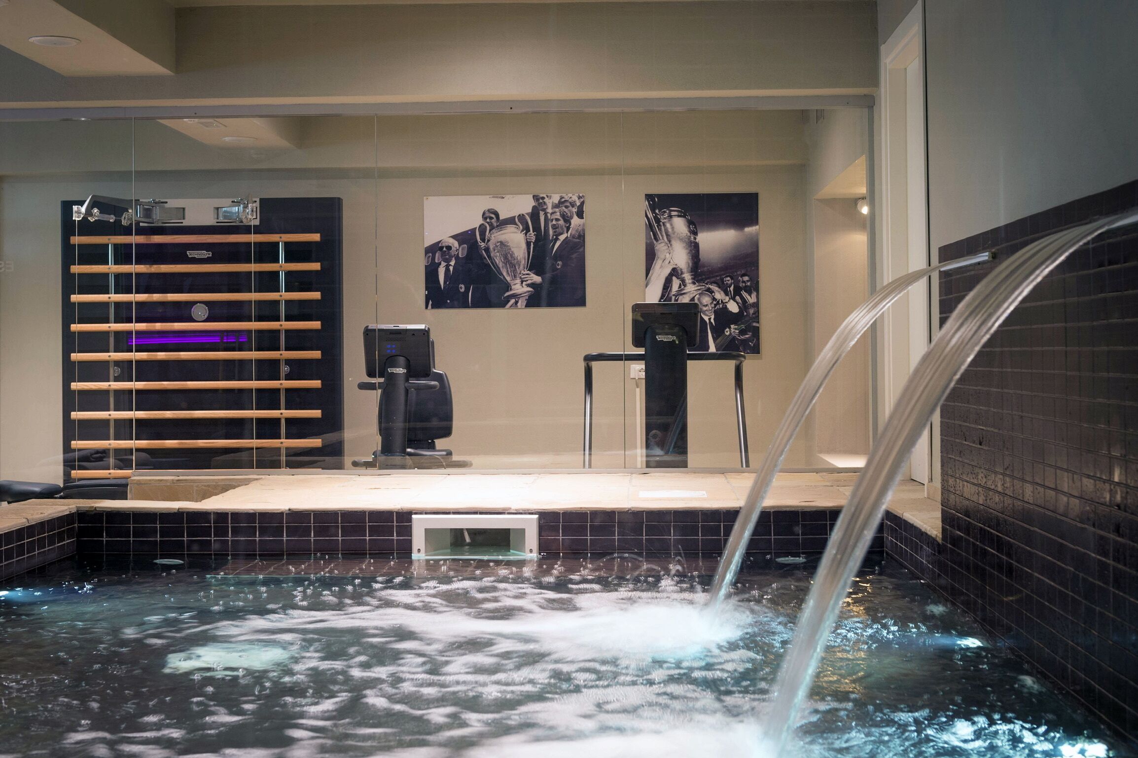 A spa area with a hot tub, a massage chair, and a wall-mounted massage table.
