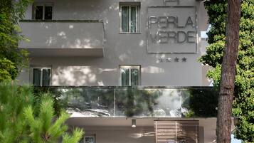 A building with the sign "PERLA VERDE" and balconies.