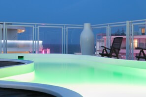Una piscina al aire libre, sillones reclinables de piscina