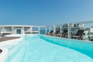 Una piscina al aire libre, sillones reclinables de piscina