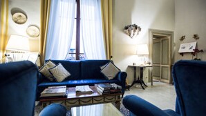 A living room with a blue sofa, two armchairs, a coffee table, and a small side table. - Hotel Burchianti (Florence)