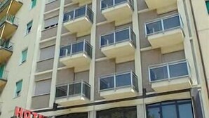 Un edificio de varios pisos con un letrero que dice 'Boston Hotel' y un letrero que indica 'Hotel Bustling'.