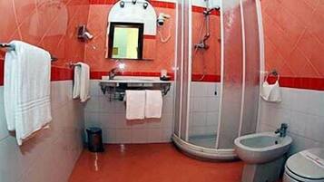 Ein Badezimmer mit Dusche, Toilette und Waschbecken.