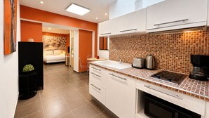 A modern kitchen with white cabinets, a tiled backsplash, and a built-in oven.