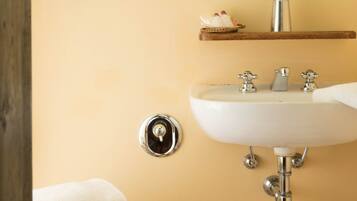 A bathroom with a toilet, sink, and mirror.
