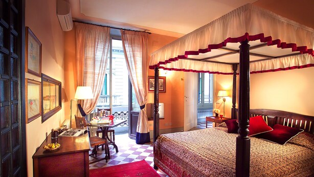 A four-poster bed with a canopy, a desk with a lamp, and a checkered floor. - Residenza Johanna I (Florence)