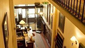 A staircase with a metal railing leading to a second floor. - Hôtel des 4 Soeurs (Bordeaux)