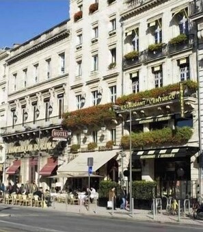 A multi-story hotel with outdoor seating and a restaurant on the ground floor. - Hôtel des 4 Soeurs (Bordeaux)