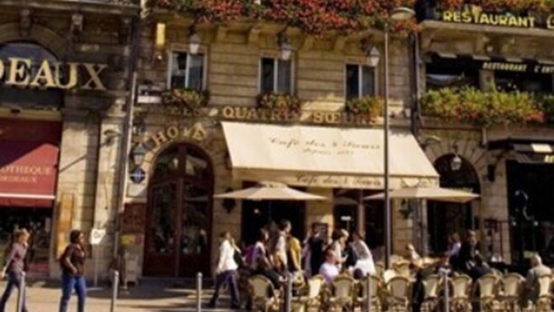 A historic building with multiple stories, featuring a ground-floor restaurant and a visible entrance with a red awning. - Hôtel des 4 Soeurs (Bordeaux)