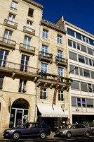 A multi-story building with a classic architectural style, featuring balconies and large windows.
