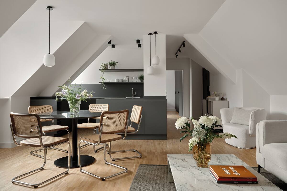 Un appartement moderne de style « loft » comprenant un coin repas, une cuisine et un espace de vie.