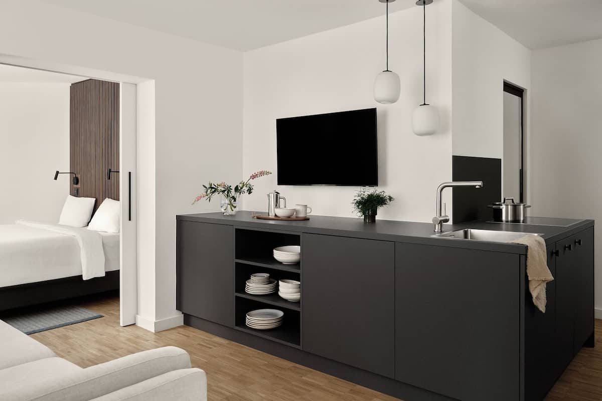 Une chambre à coucher moderne et minimaliste, avec un grand lit, une table de chevet et une commode.