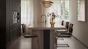 A modern kitchen with a central island, stainless steel appliances, and a large window providing natural light. - Bob W Munich Schwabing (Munich)