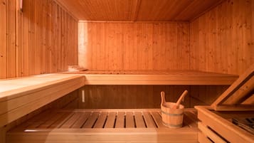 Una sauna de madera con bancos y un balde con una cuchara.