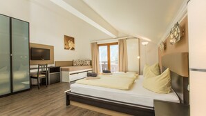 Una habitación de hotel moderna con una cama grande, un escritorio, una silla, un televisor y una puerta corredera.