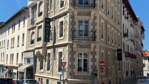 A historic hotel with a stone facade, multiple balconies, and a sign indicating it is a hotel. - AMA Hôtel (Biarritz)