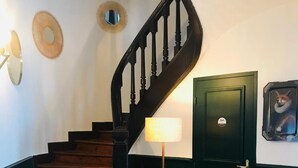 A wooden staircase with a black handrail leading to a green door. - AMA H ôtel (Biarritz)