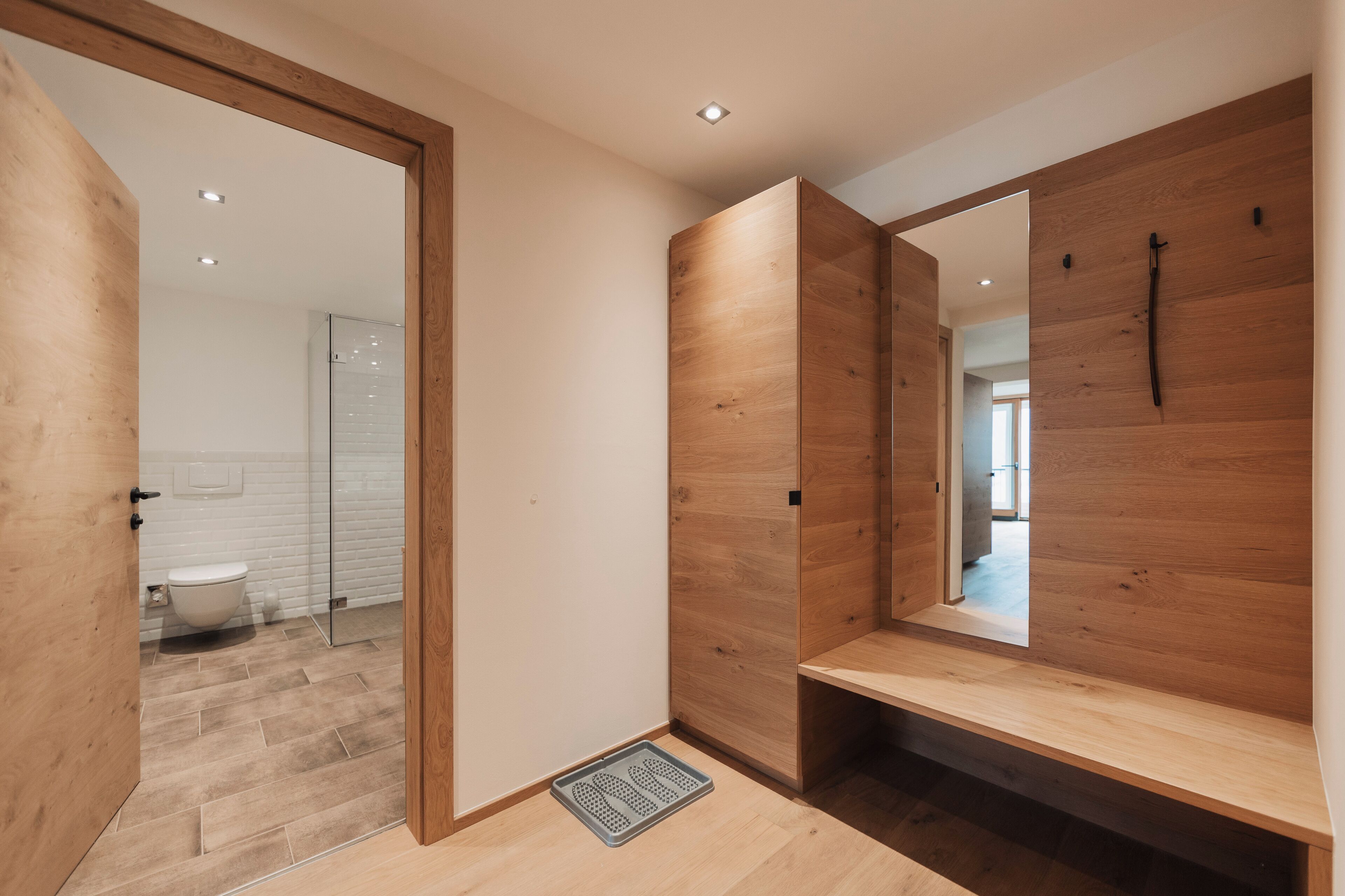 Ein modernes Badezimmer mit Holzwänden, einer Duschkabine aus Glas und einem sichtbaren WC.