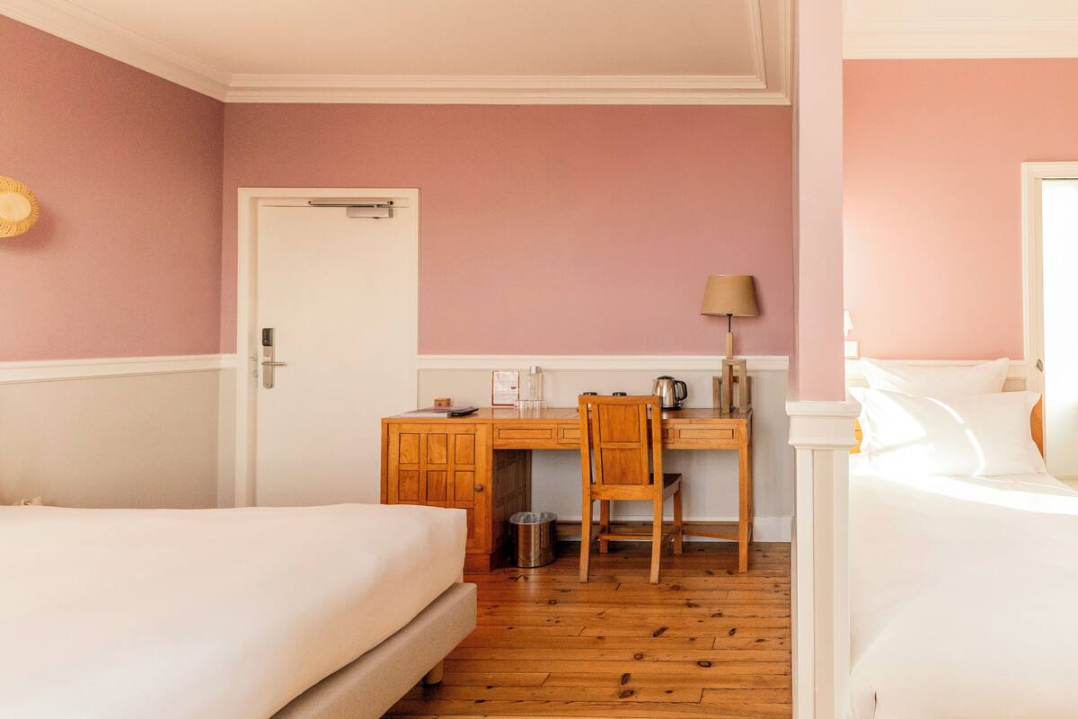 Ein Schlafzimmer mit zwei Betten, einem Schreibtisch und einem Stuhl.
