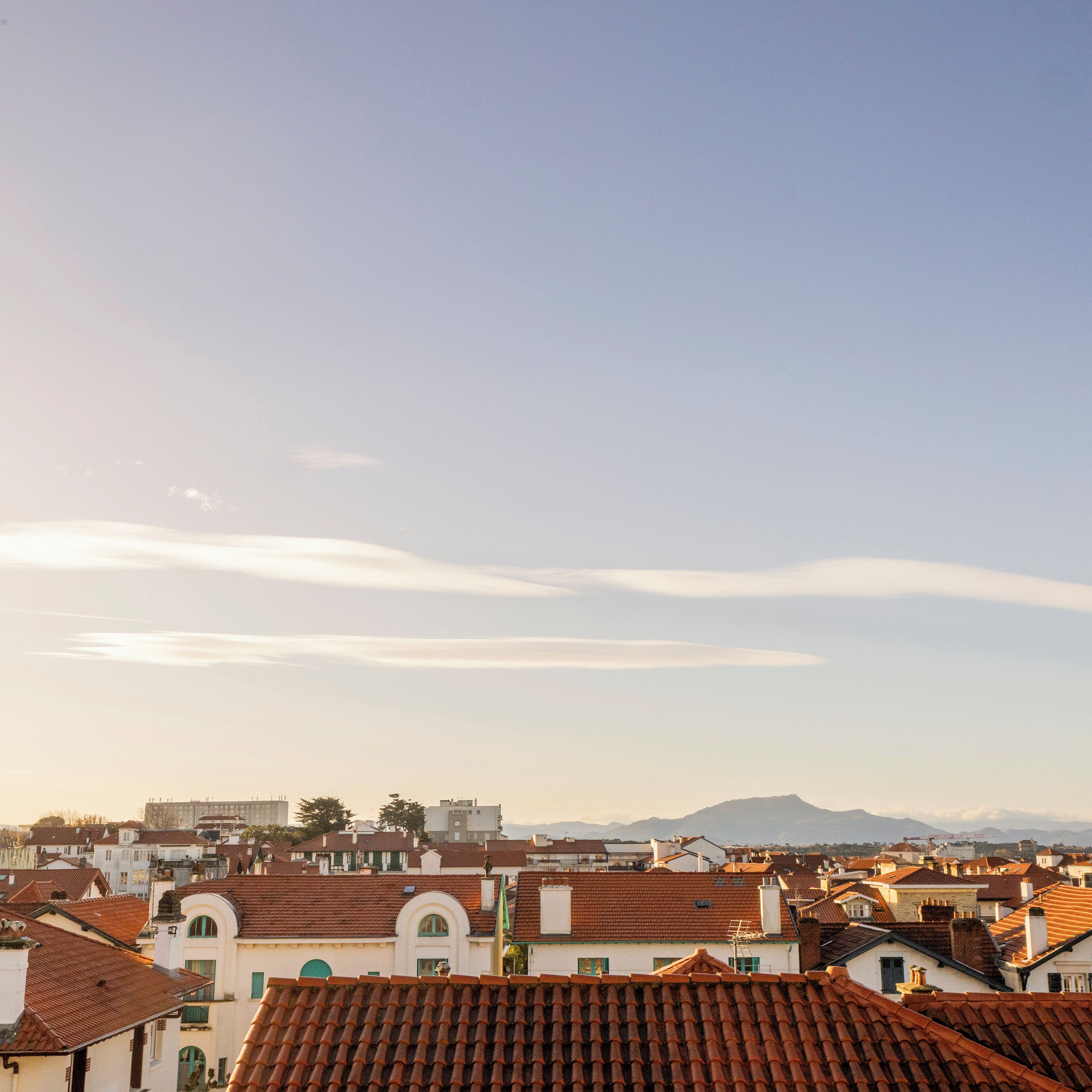 A cityscape with traditional architecture, including buildings with red-tiled roofs and white facades.
