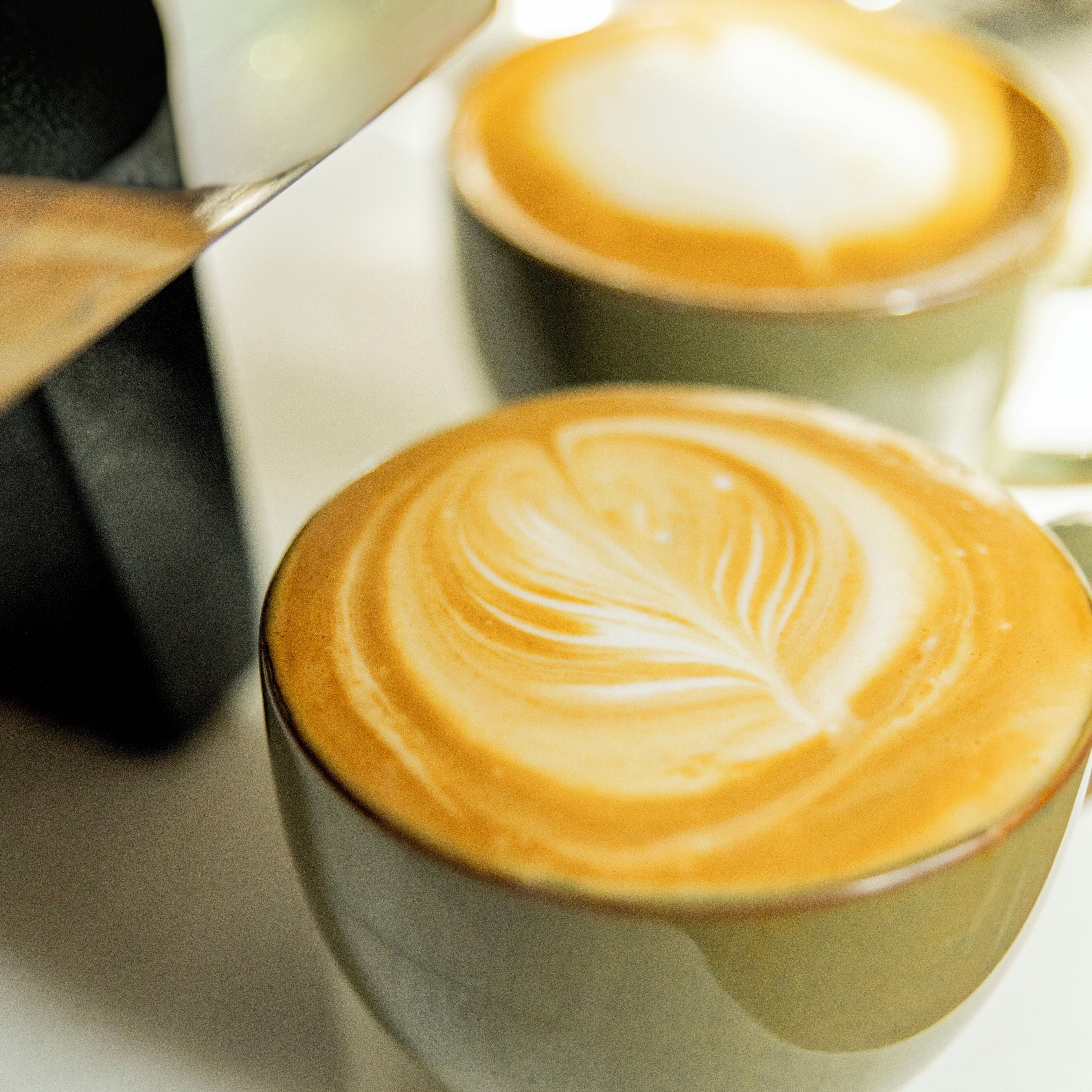 Un gros plan d’une tasse de café ornée d’un motif réalisé avec de la mousse de lait.