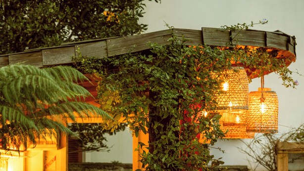 A wooden pergola with climbing plants, a staircase, and a hanging light fixture. - Hôtel St-Julien (Biarritz)
