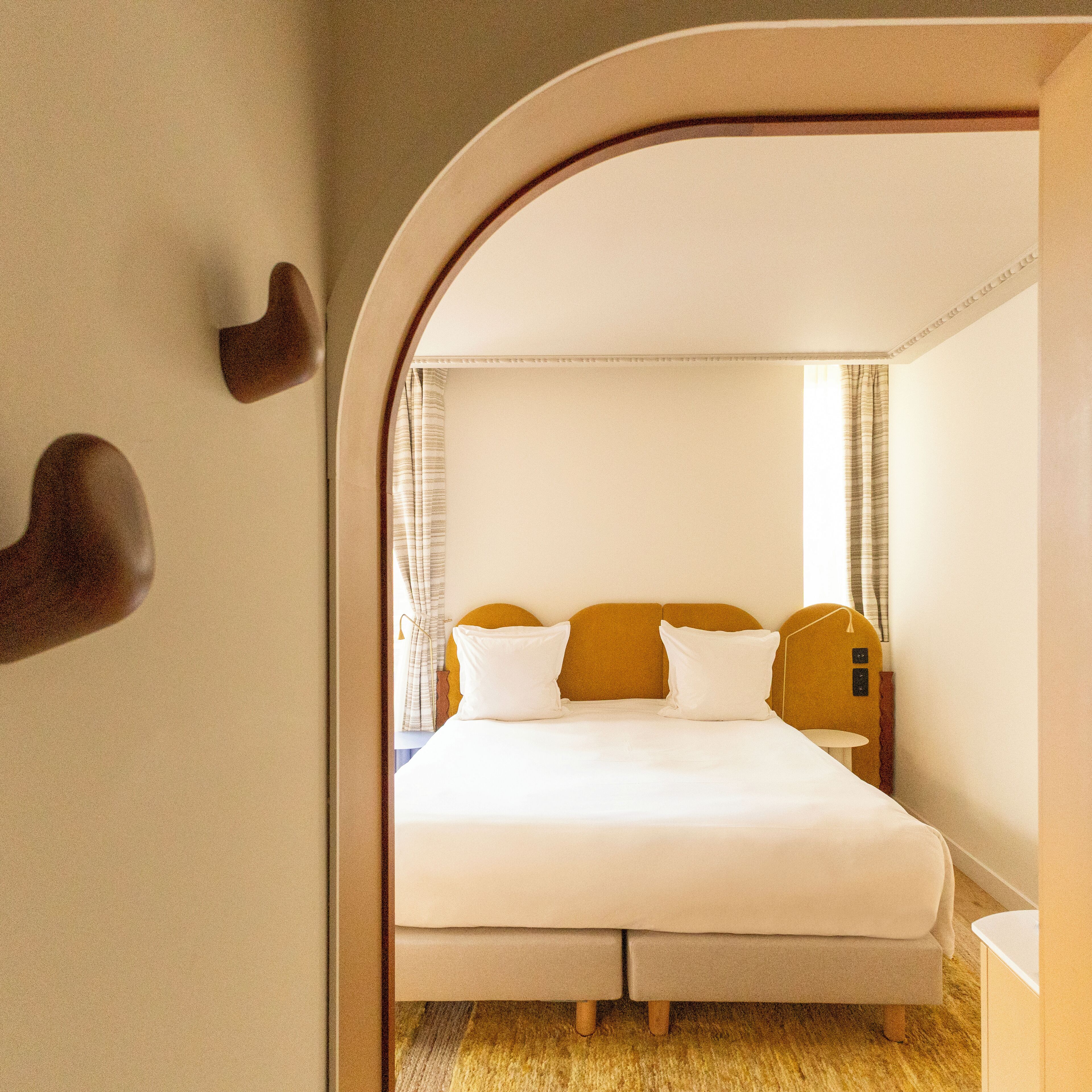 Ein Schlafzimmer mit Bett, Kissen und Vorhängen.