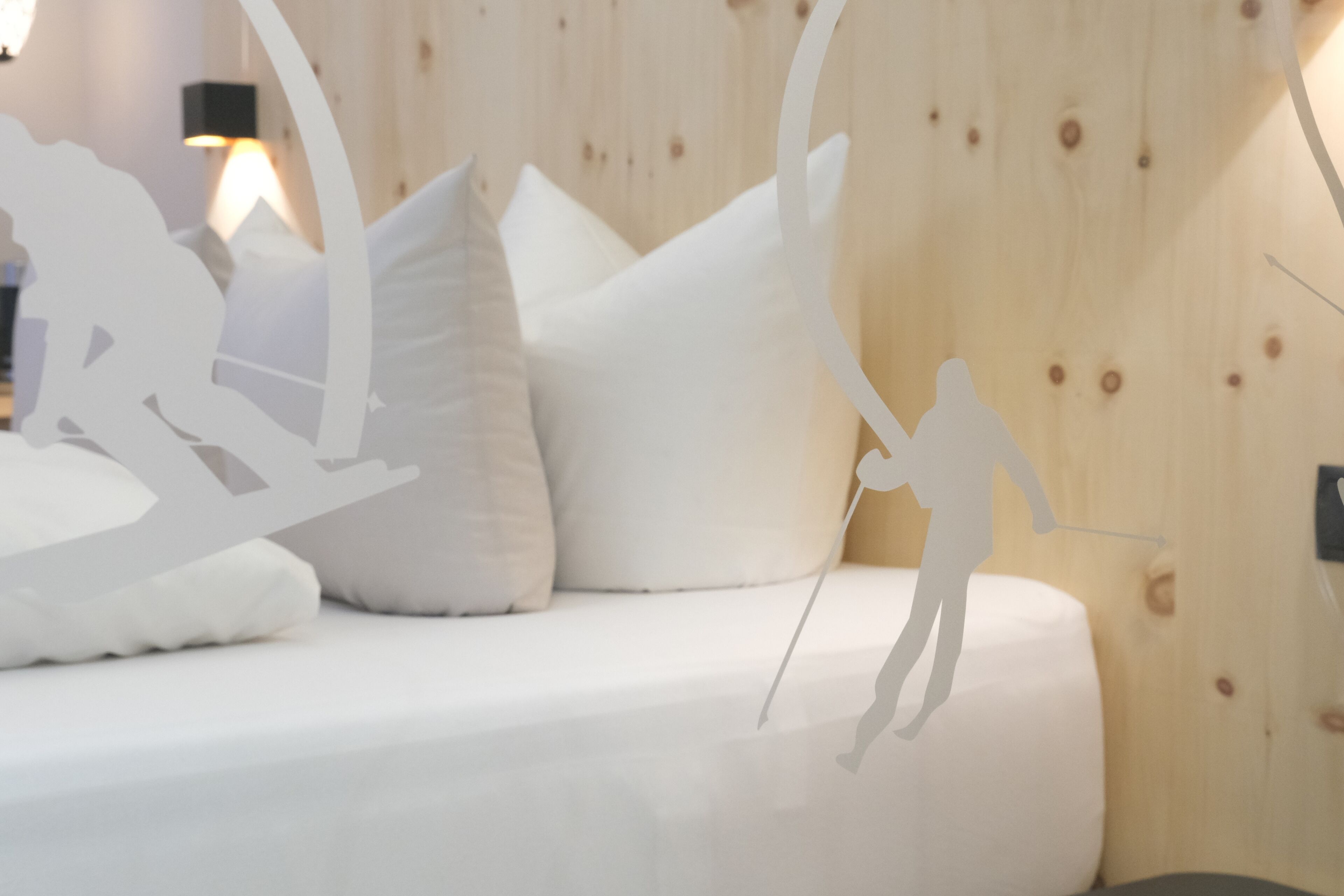 A bed with white bedding and multiple pillows.