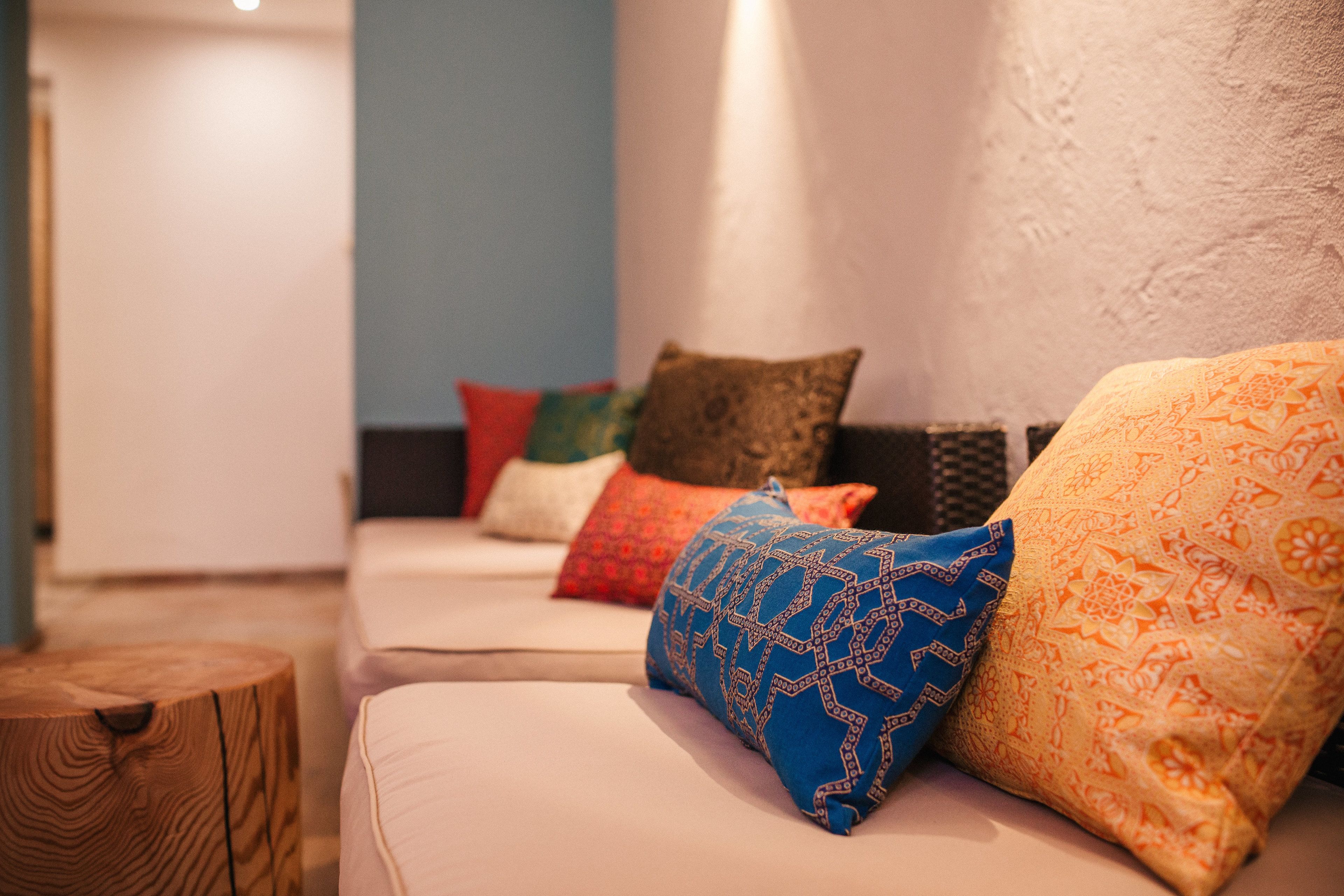 A modern living room with a sofa adorned with colorful patterned cushions.