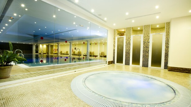 A large indoor swimming pool with a hot tub, seating area, and a glass wall. - Hotel Monarque Cendrillón (Fuengirola)