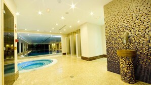 A swimming pool area with a tiled floor, a wall with mosaic tiles, and a sink. - Hotel Monarque Cendrillón (Fuengirola)