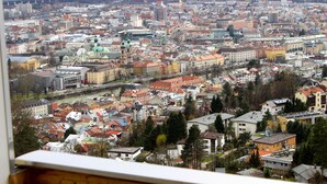 Vista panorámica de un paisaje urbano con un río que lo atraviesa, varios edificios y un puente a lo lejos.