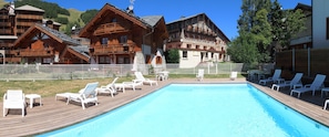 Piscine extérieure en saison, chaises longues