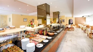 A buffet setup with various food items and a seating area with tables and chairs. - Hotel Monarque El Rodeo (Marbella)