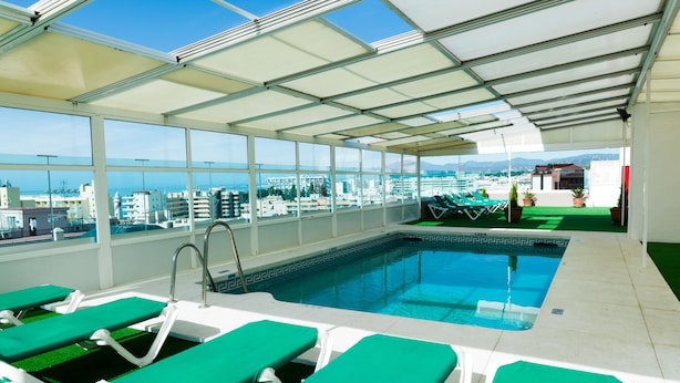 A rooftop pool with green lounge chairs and a clear view of the cityscape. - Hotel Monarque El Rodeo (Marbella)